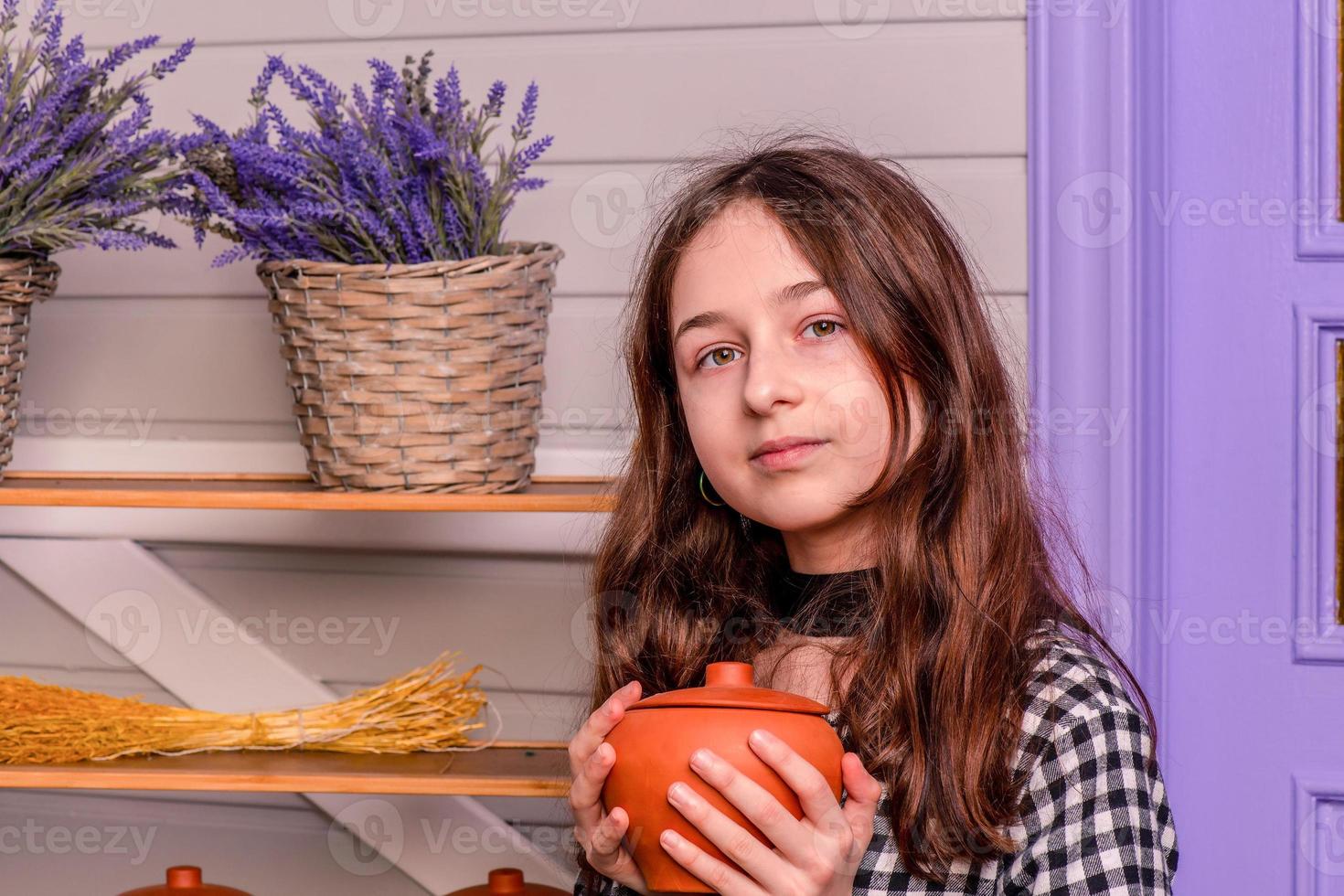 retrato de uma adolescente em um vestido xadrez. menina com um vaso de flores nas mãos dela. foto