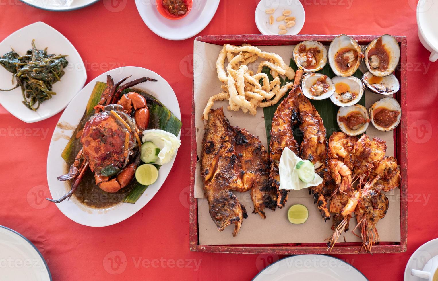frutos do mar com lagosta, caranguejo, peixe, camarão, marisco na bandeja de madeira no restaurante foto