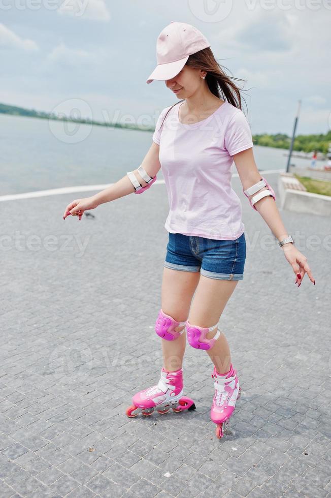 retrato de uma jovem bonita em roupas casuais, patins na calçada do parque. foto