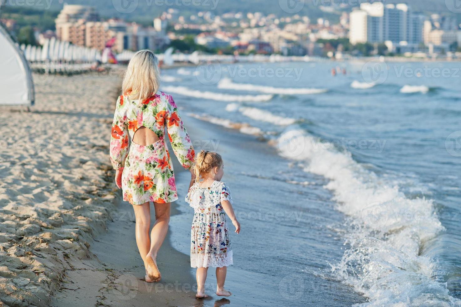 mãe e filha linda se divertindo na praia. retrato de mulher feliz com menina bonitinha de férias. foto