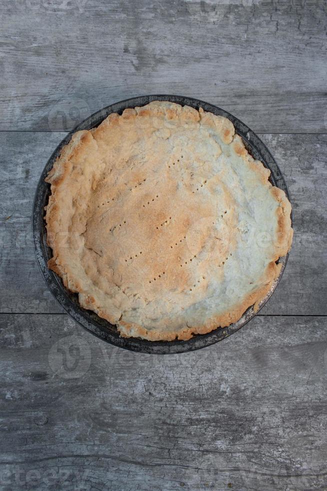 casca de torta caseira rústica vazia assada com furos na forma plana de torta de estanho foto