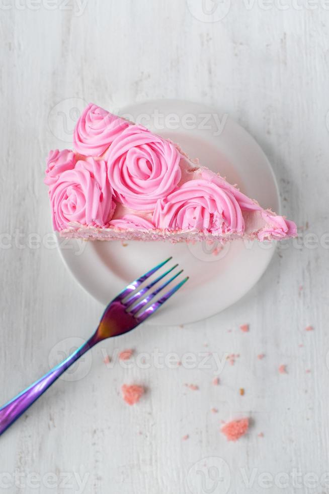 fatia fina festiva de bolo de aniversário rosa com flores de glacê e garfo flat lay foto