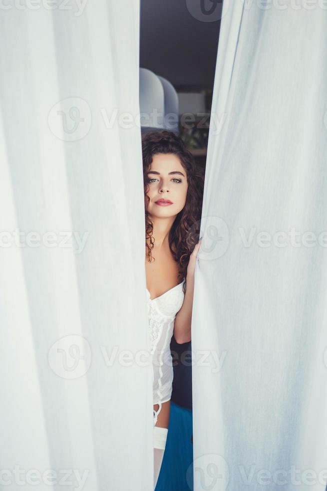 retrato de uma mulher encaracolada em lingerie branca foto