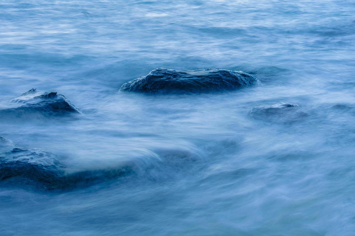 onda oceânica suave de longa exposição movendo-se em rocha. foto