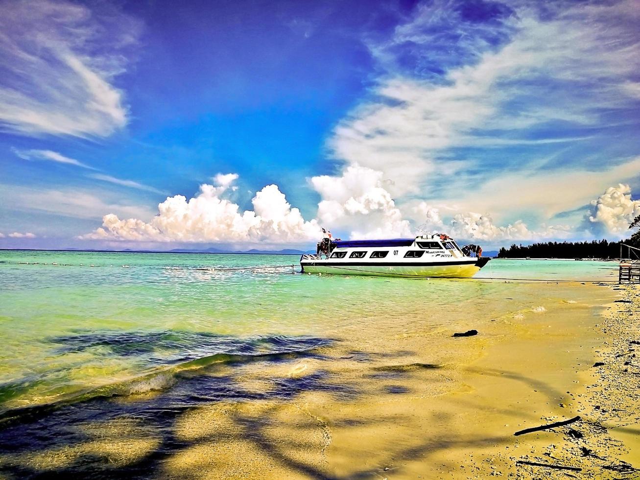 destino de viagem, malásia. bandeira de sabah no barco à vela ilha de mantanani foto