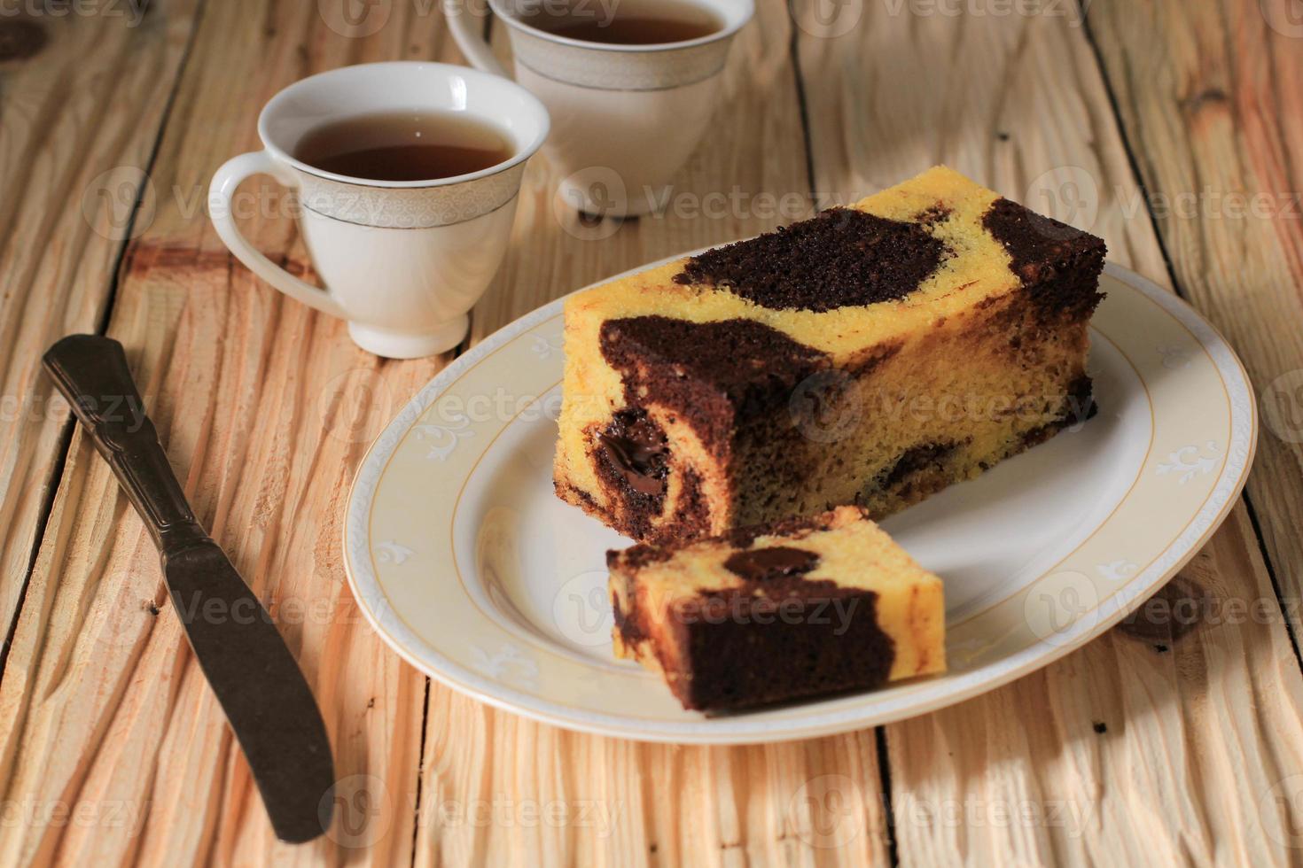 bolo de viagem em mármore, mini bolo mármore de pão com chocolate derretido no interior. também conhecido como bolo de tubo. servido na chapa branca foto