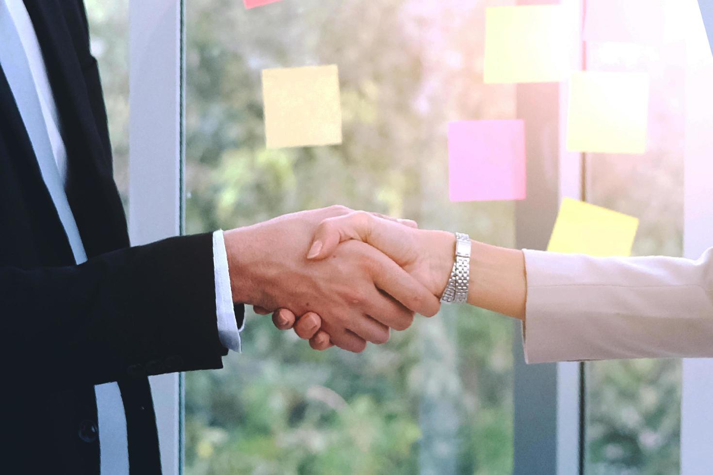 empresário de sucesso e empresária feliz e aperta as mãos após a reunião para parceria no escritório moderno foto