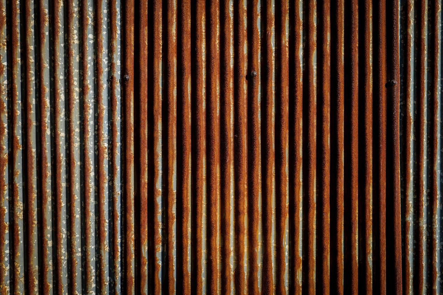 cerca galvanizada de sulco vertical velha e enferrujada, fundo abstrato. foto