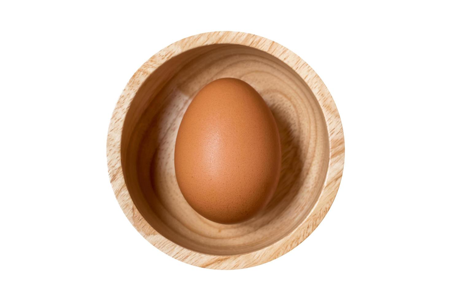close-up de ovo cru orgânico em tigela de madeira isolado no caminho background.clipping branco incluído. foto
