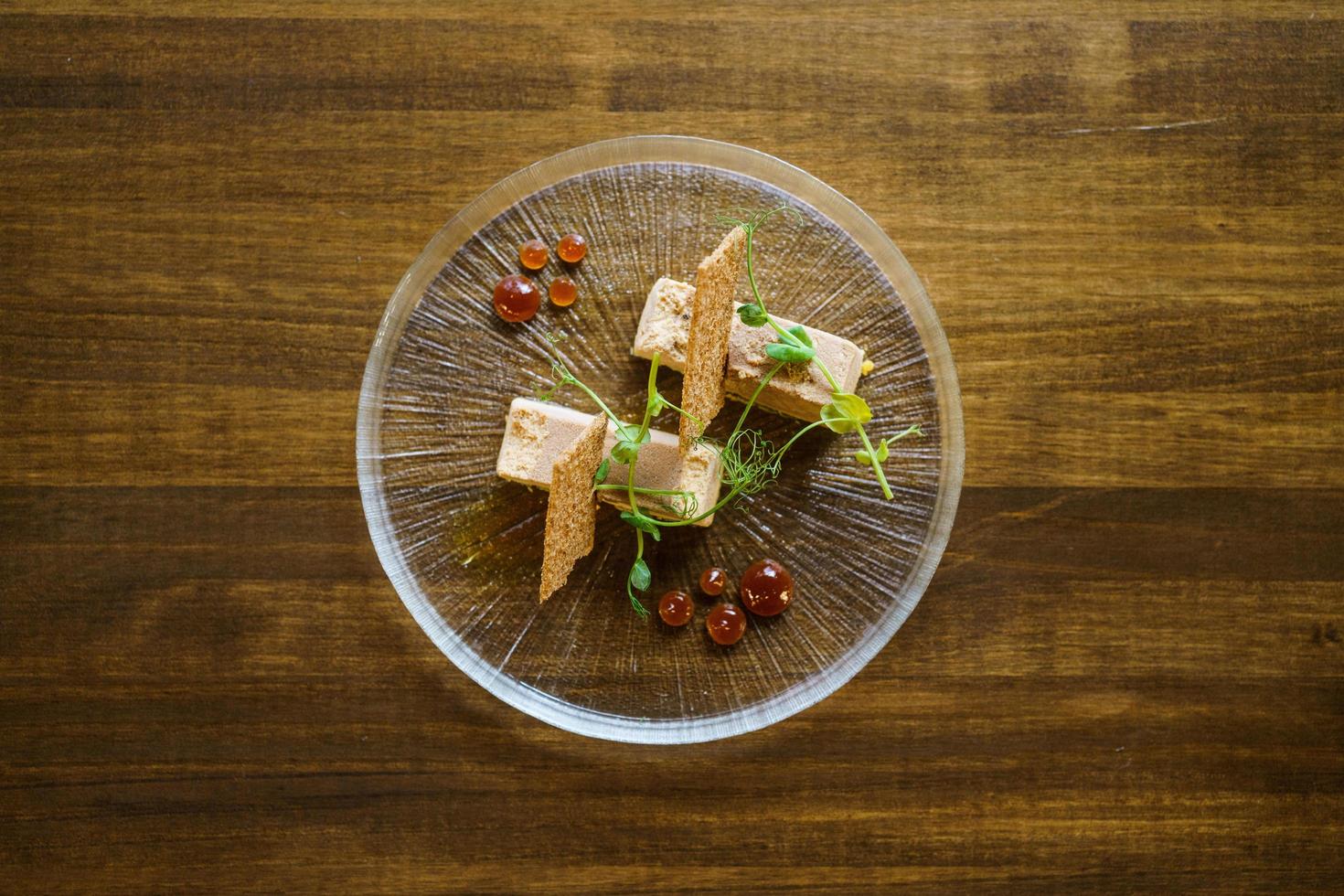 vista superior do prato de foie micuit com croutons crocantes e gotas de marmelada. foto