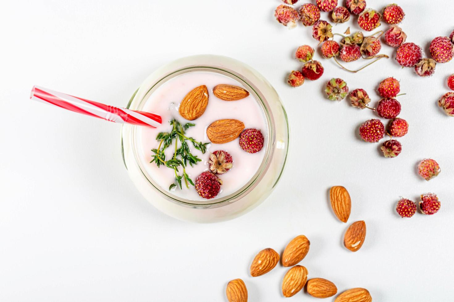 vista superior de iogurte com morangos e amêndoas em um fundo branco foto