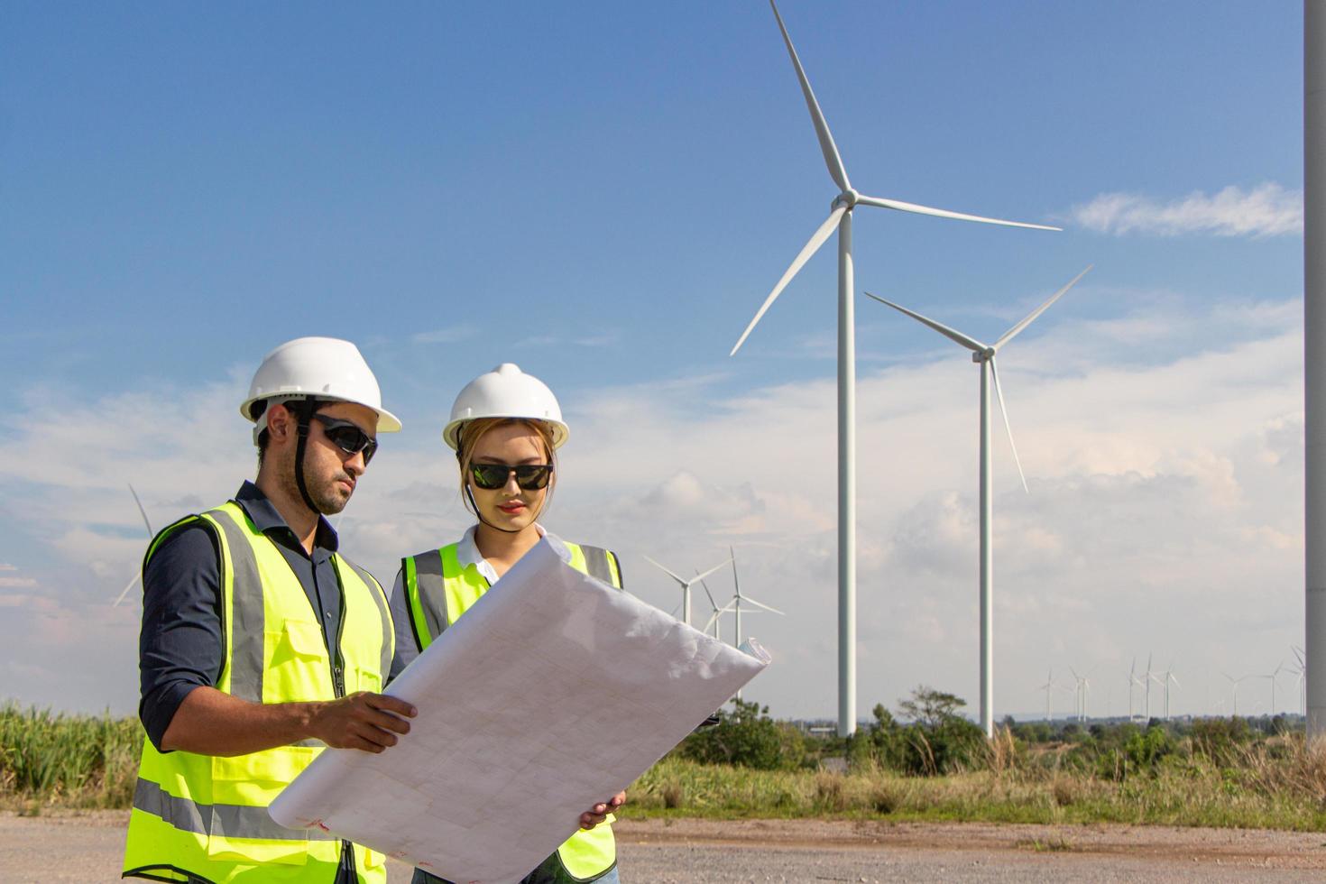 equipe de engenheiros trabalhando na fazenda de turbinas eólicas. energia renovável com gerador eólico pelo conceito de energia alternativa. foto