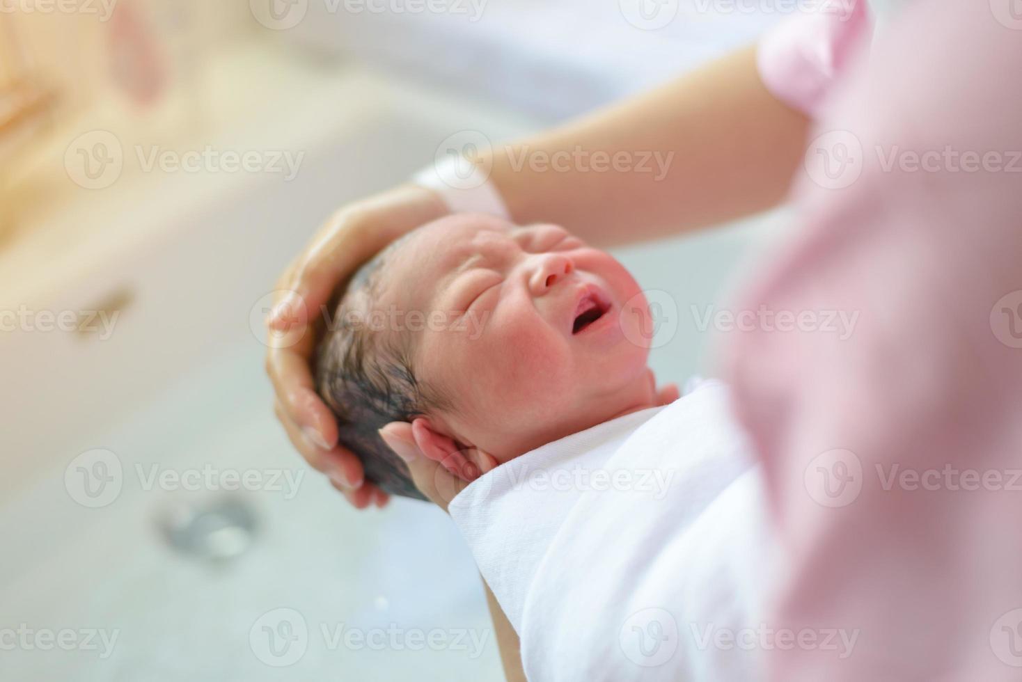 asiático recém-nascido tomando banho por sua mãe, menino foto