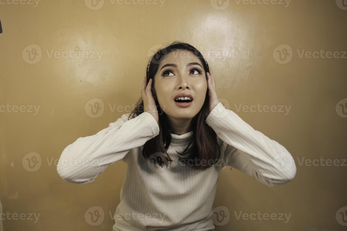 confunda gesto de menina bonita asiática com uma camisa branca. foto