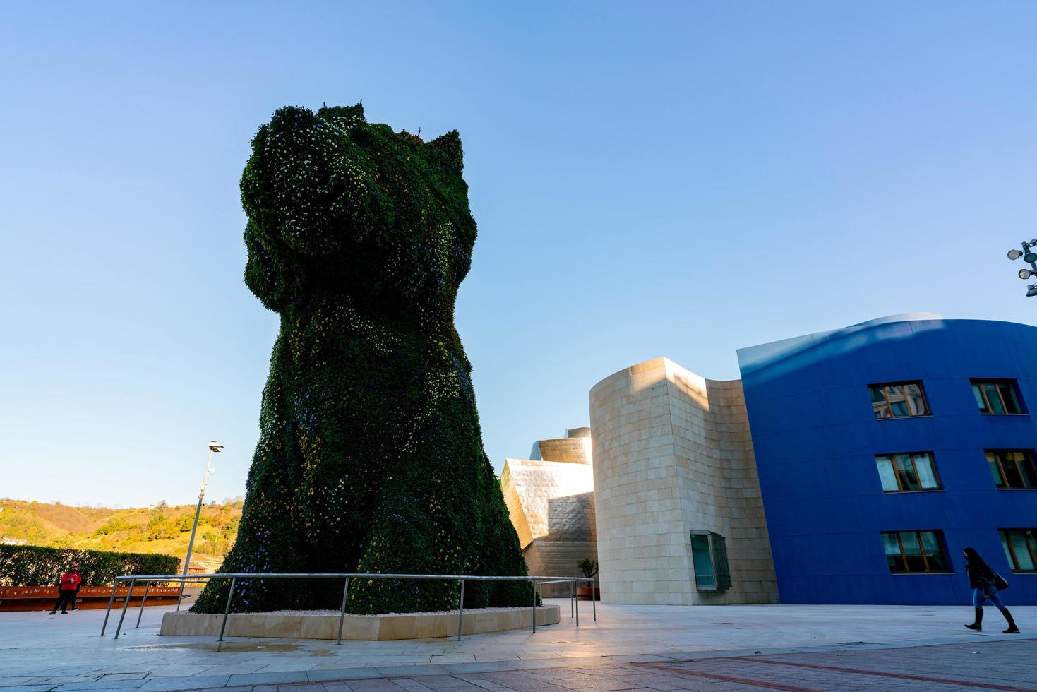 bilbao, espanha-18 de dezembro de 2021 cachorro monta guarda no museu guggenheim em bilbao, biscaia, país basco, espanha. marcos. escultura de cachorro do artista jeff koons. a maior escultura de flores do mundo. foto