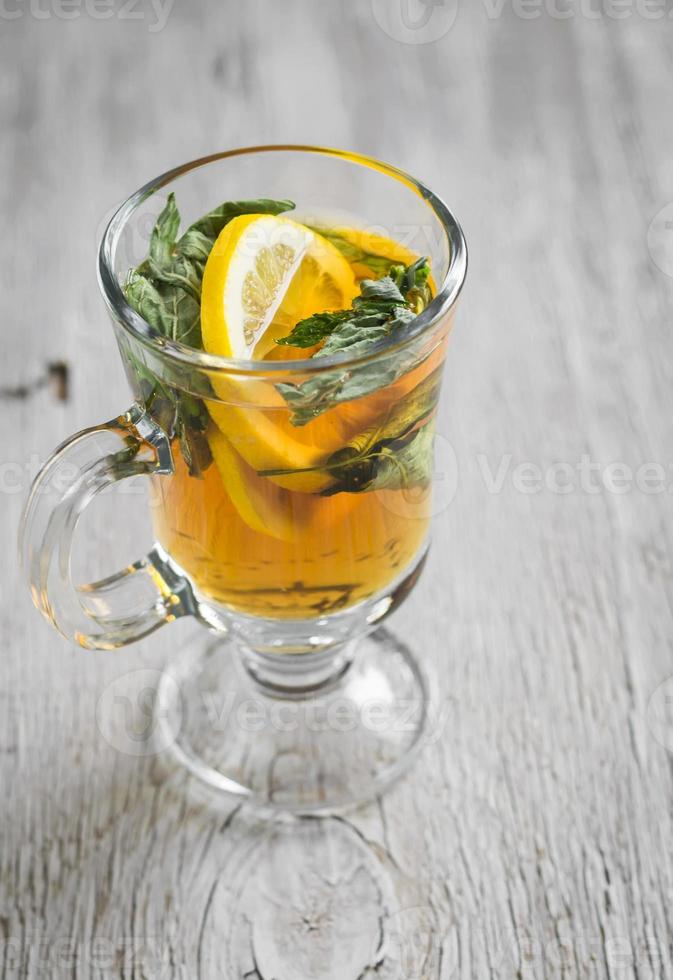 chá verde com hortelã e limão em uma caneca de vidro foto