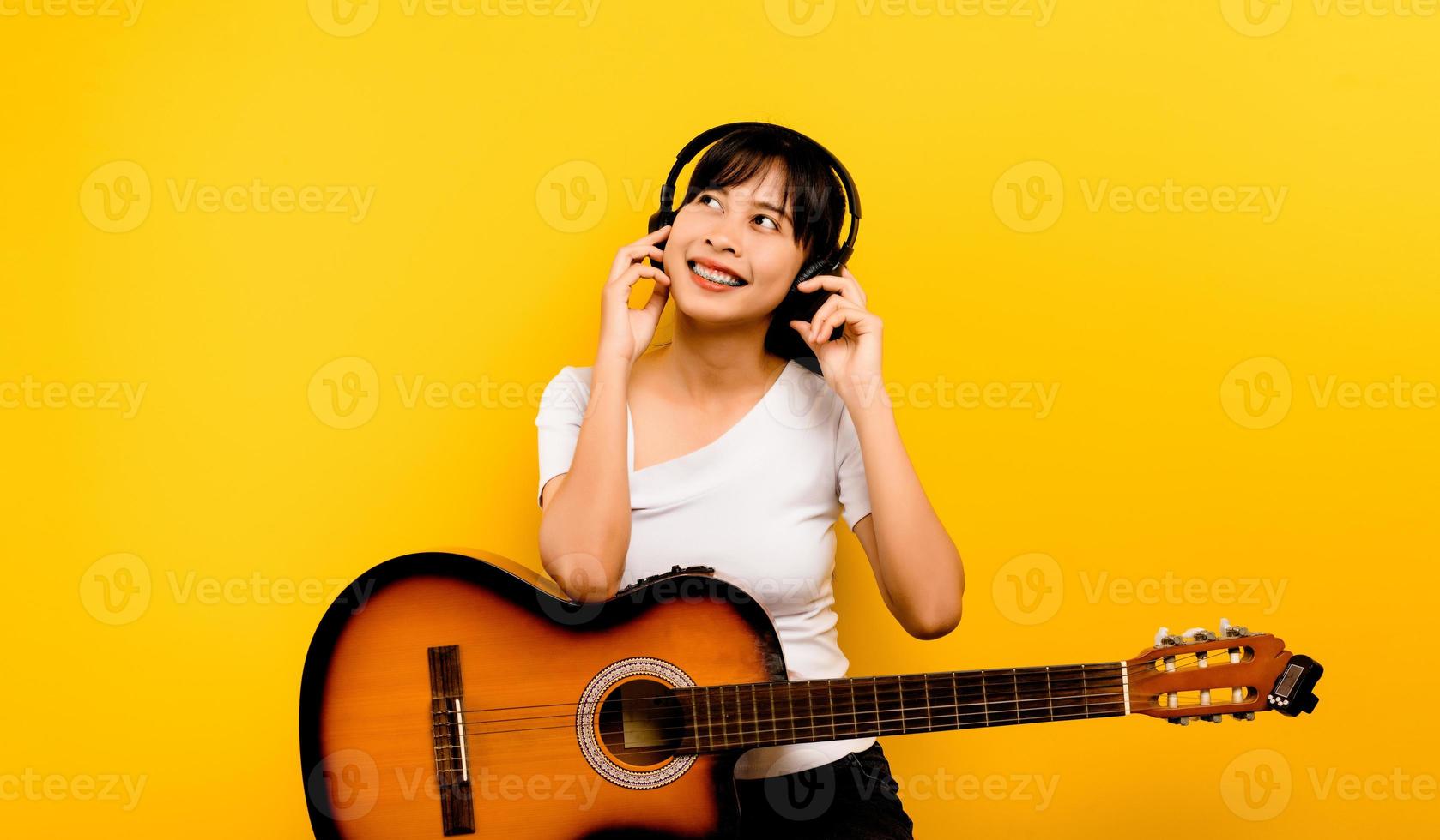 mulher ouvindo música uma jovem mulher asiática em um vestido branco sorri alegremente. pessoas felizes conceito de estilo de vida copiar maquete de espaço ouvir música com fones de ouvido foto