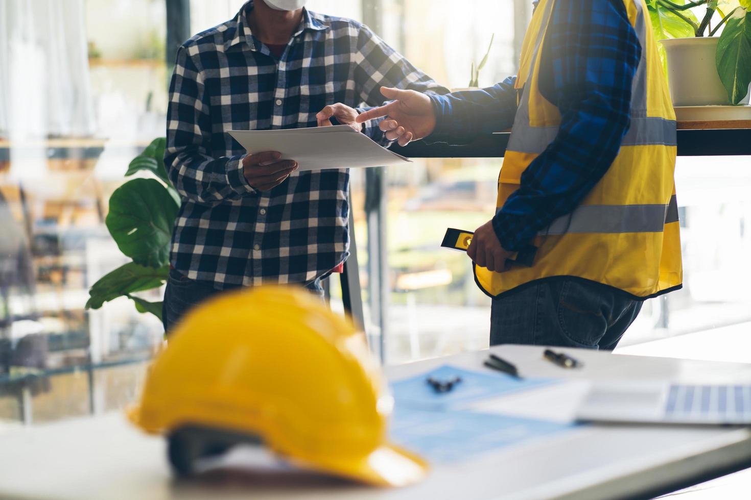 arquitetos conceituais, engenheiro segurando caneta apontando arquitetos de equipamentos na mesa com uma planta no escritório, engenheiros e arquitetos trabalham em projetos de brainstorming. foto