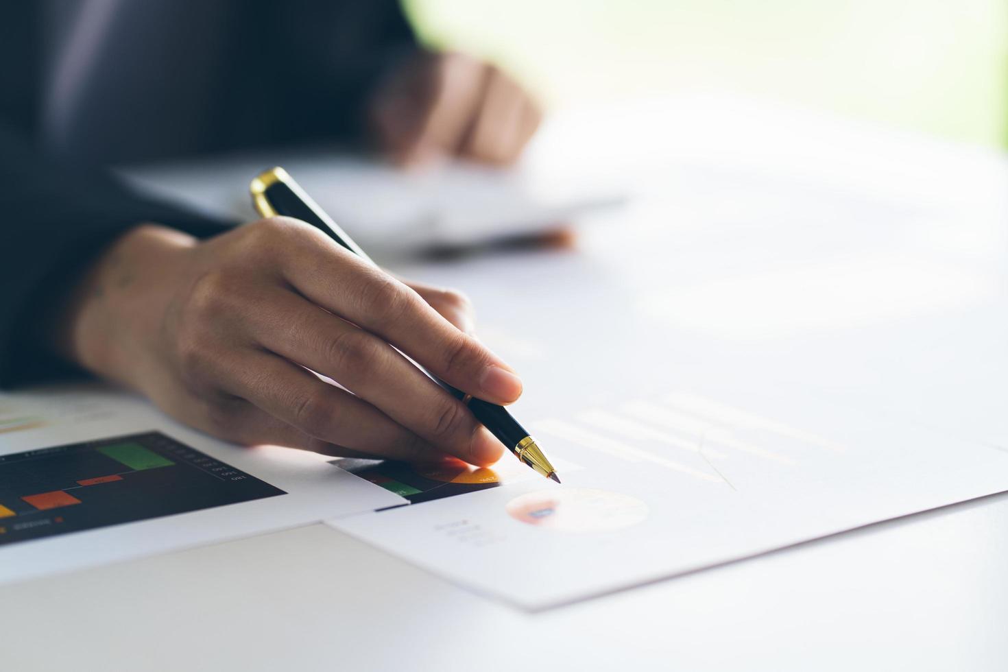 caneta de mão de empresária apontando no documento de negócios na reunião de discussão e análise de dados os gráficos e gráficos mostrando os resultados no conceito financeiro e contábil meeting.business. foto