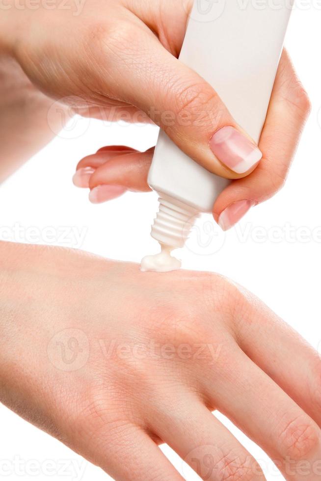 mulher aplicando creme hidratante nas mãos foto