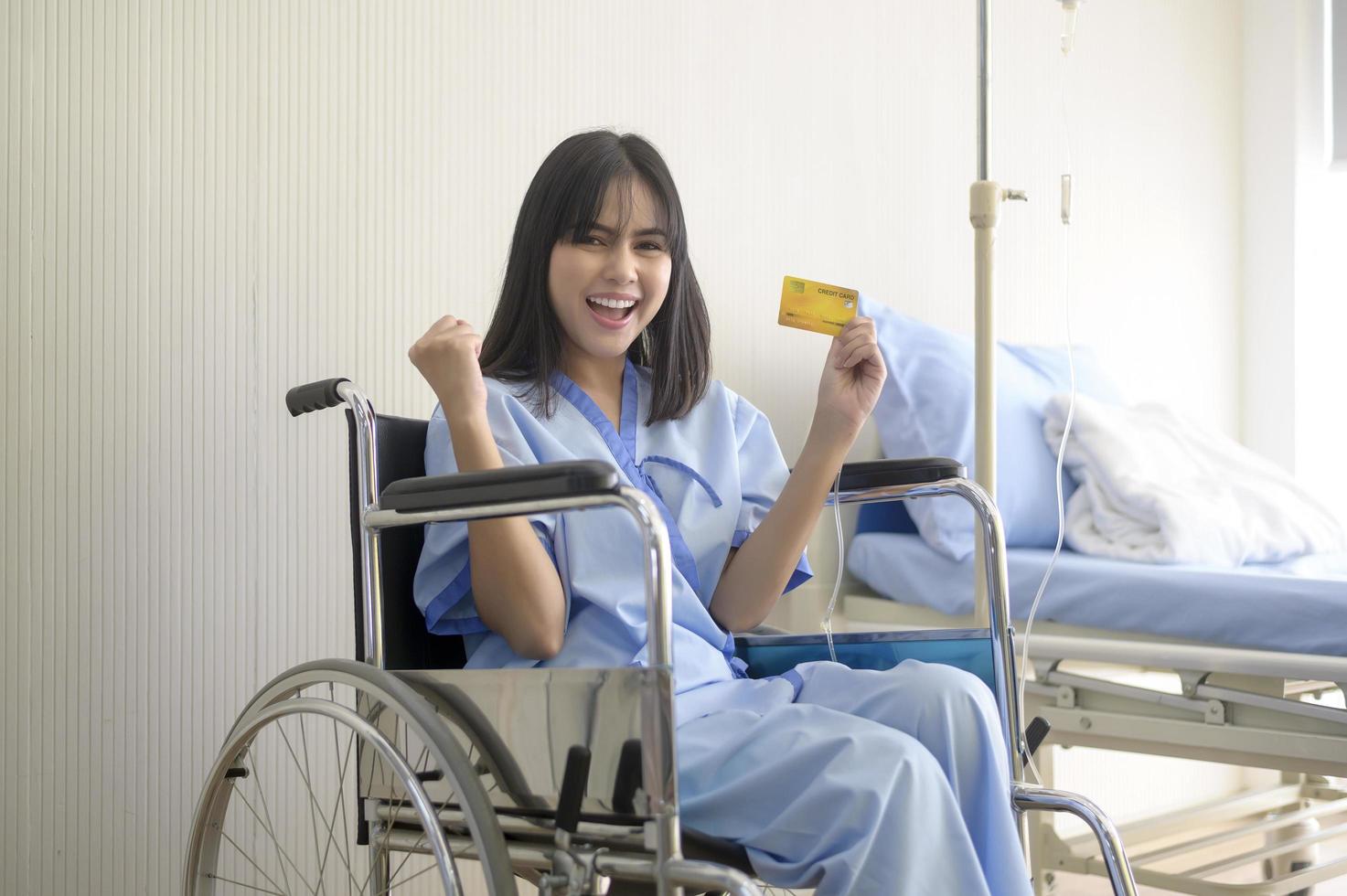 uma jovem paciente está segurando cartão de crédito, admitindo no hospital, conceito de cuidados de saúde foto