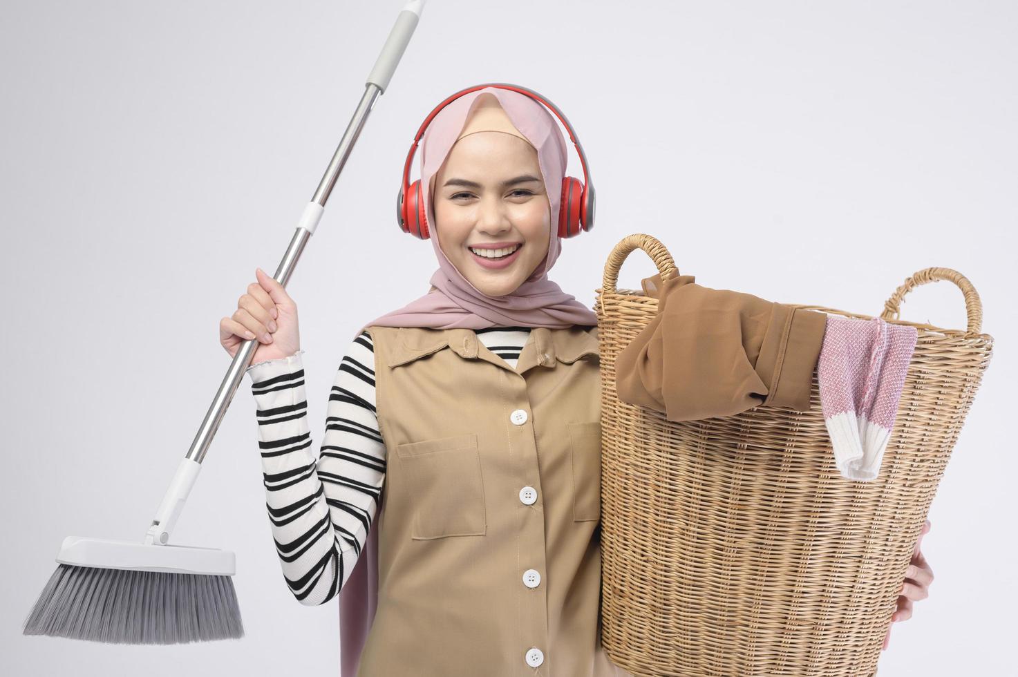 jovem muçulmana linda dona de casa sorrindo em fundo branco foto