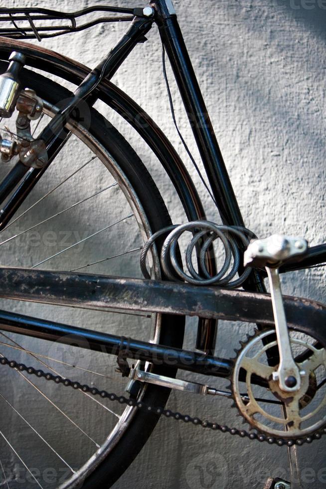 detalhe de um pedal de bicicleta vintage com corrente e cadeado foto