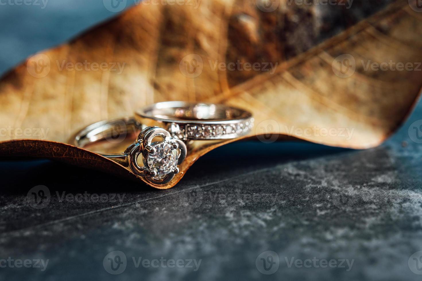 closeup de um anel de noivado de diamante colocado em uma folha. conceito de amor e casamento. foto