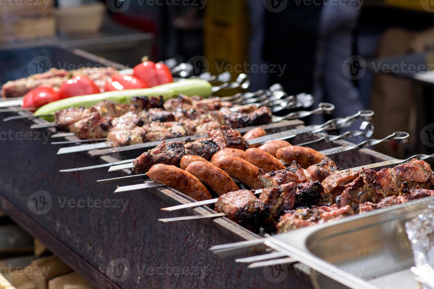 espetos de carne grelhados na brasa, com fumaça. comida de rua. foto