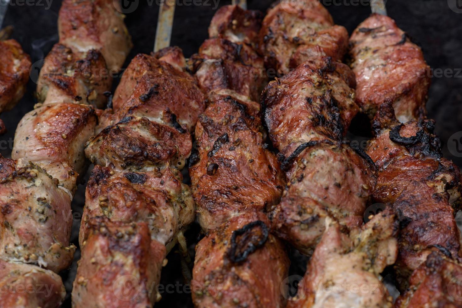 espetos de carne grelhados na brasa, com fumaça. comida de rua. foto