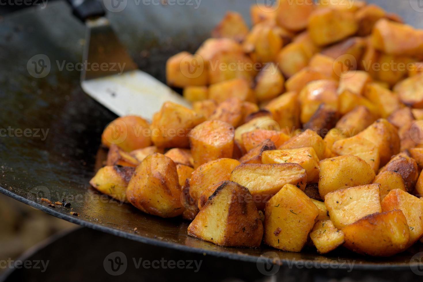 pedaços de batatas fritas em uma frigideira grande durante o festival de comida de rua. foto