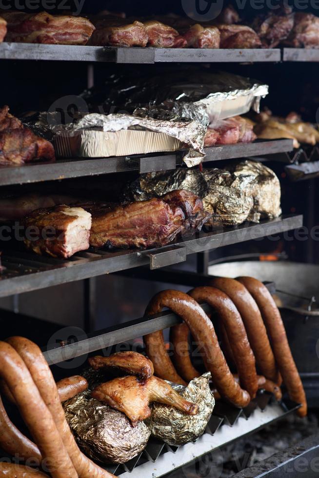 espetos de carne grelhados na brasa, com fumaça. comida de rua. foto