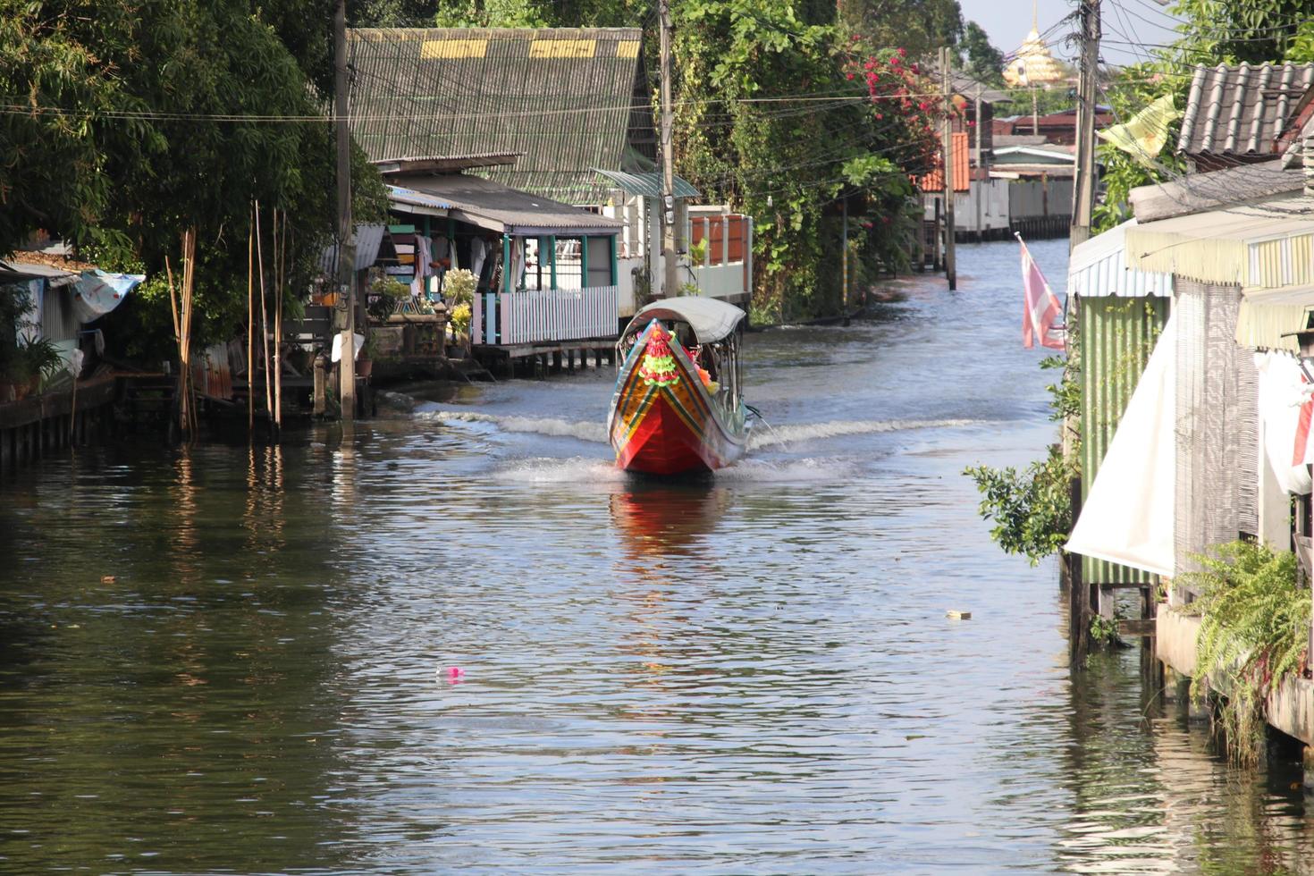 barco de cauda longa está navegando no canal, bangkok, tailândia. foto