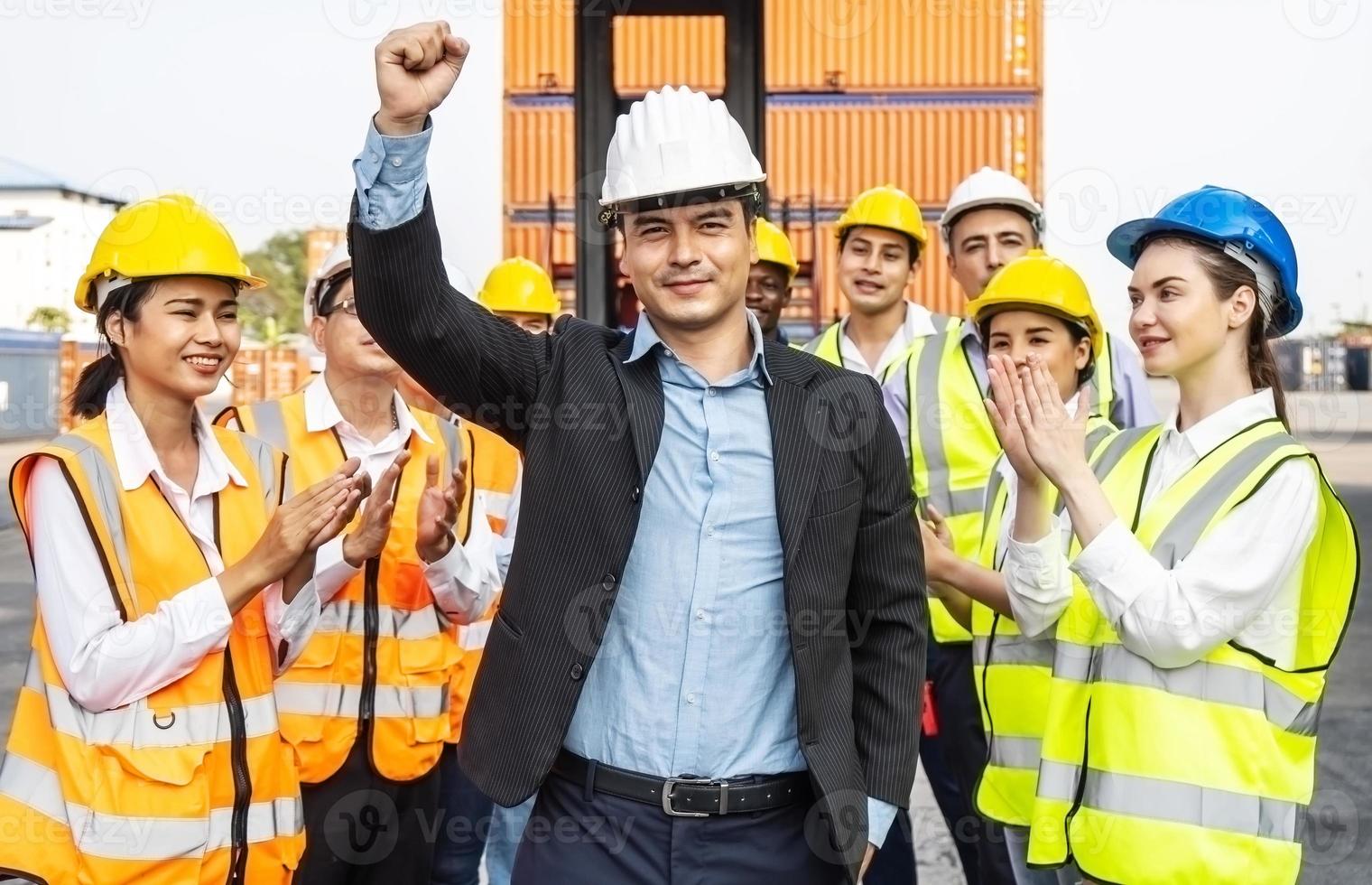 equipe profissional de engenharia e trabalhadores parabenizou o sucesso aplaudindo seu líder após a conclusão do projeto de construção e ele levantou sua mão alegremente foto