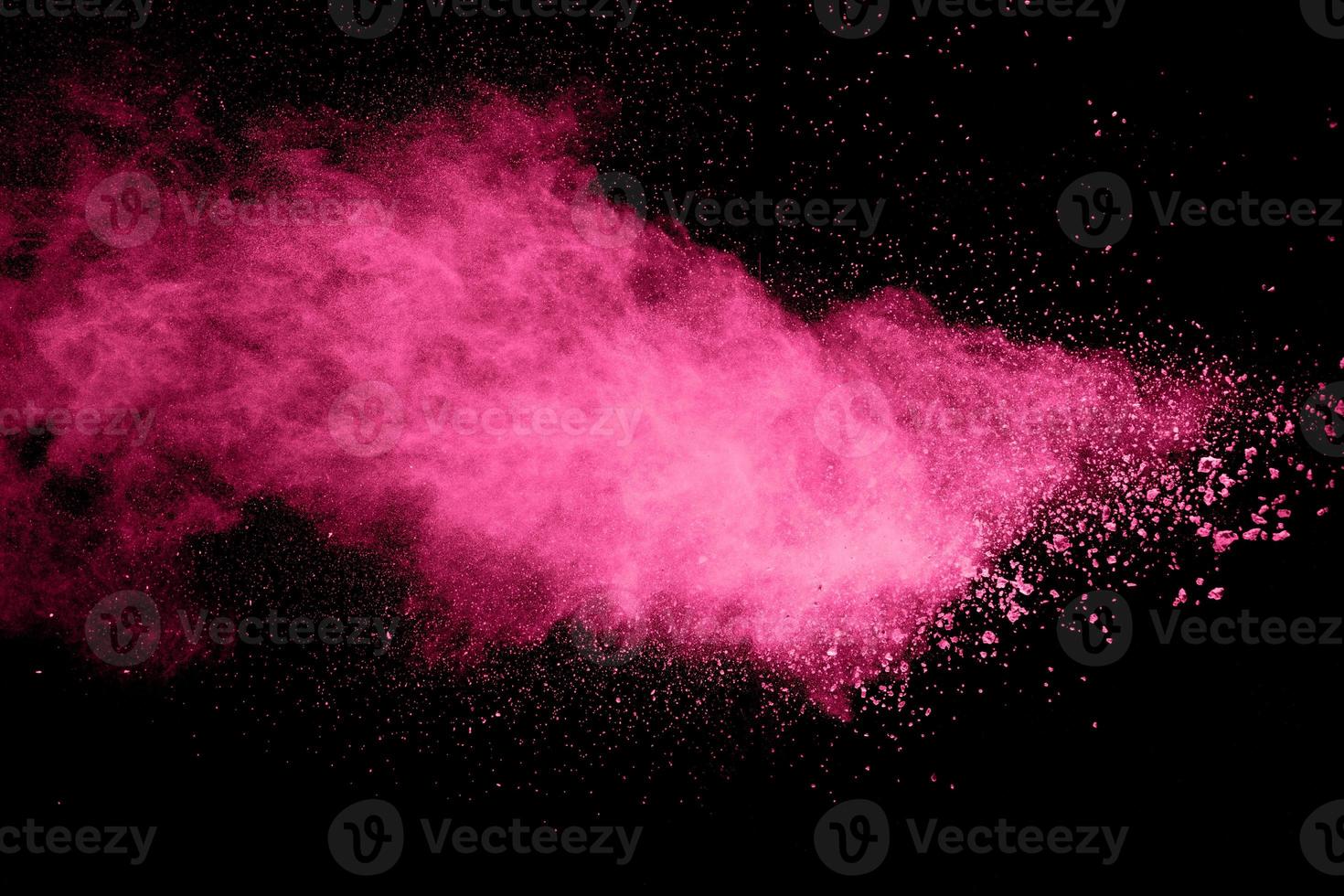 explosão de pó rosa em fundo preto. foto