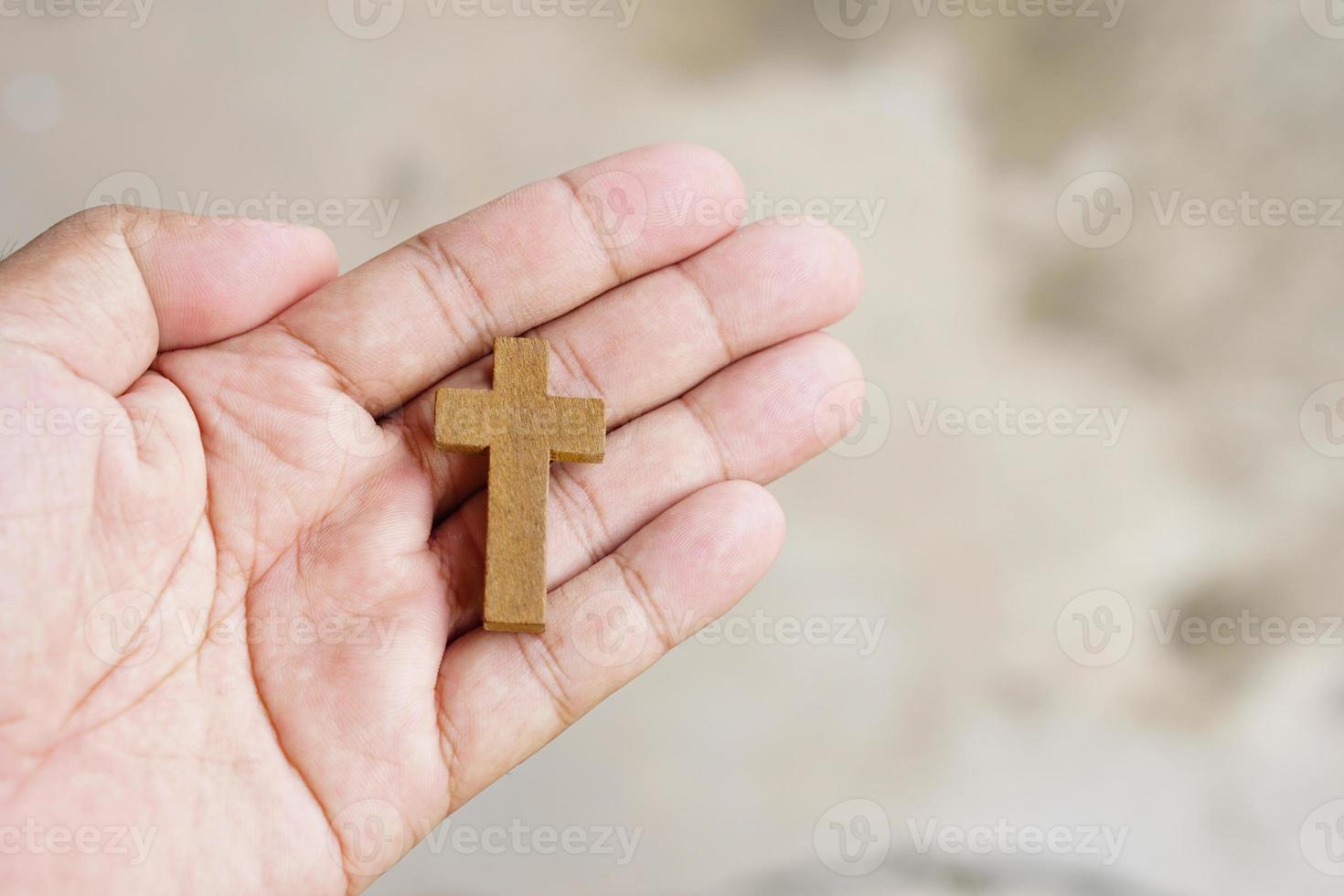 cruz representando jesus na mão humana foto