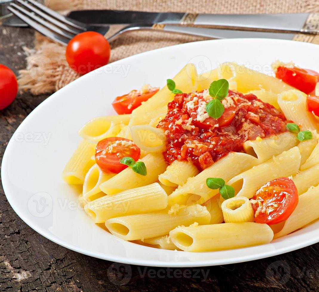 macarrão penne com molho bolonhesa, queijo parmesão e manjericão foto