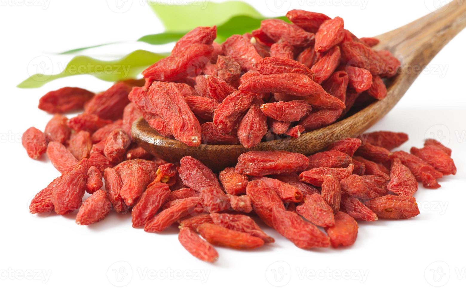 bagas vermelhas secas de goji em colher de pau foto