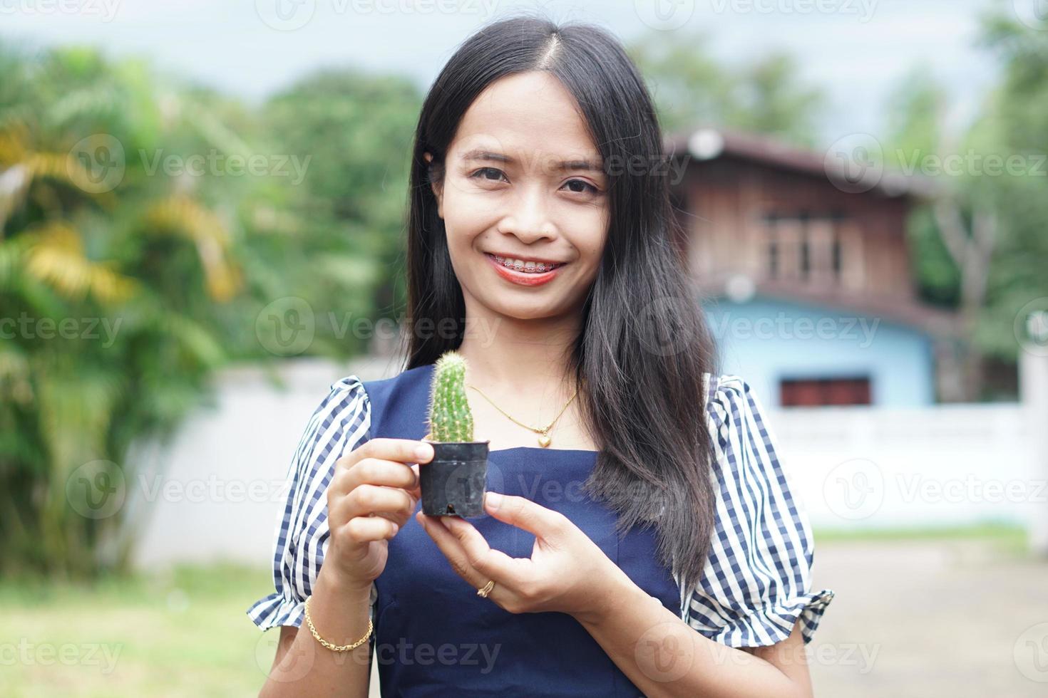 mulher asiática segurando um pote de cacto foto