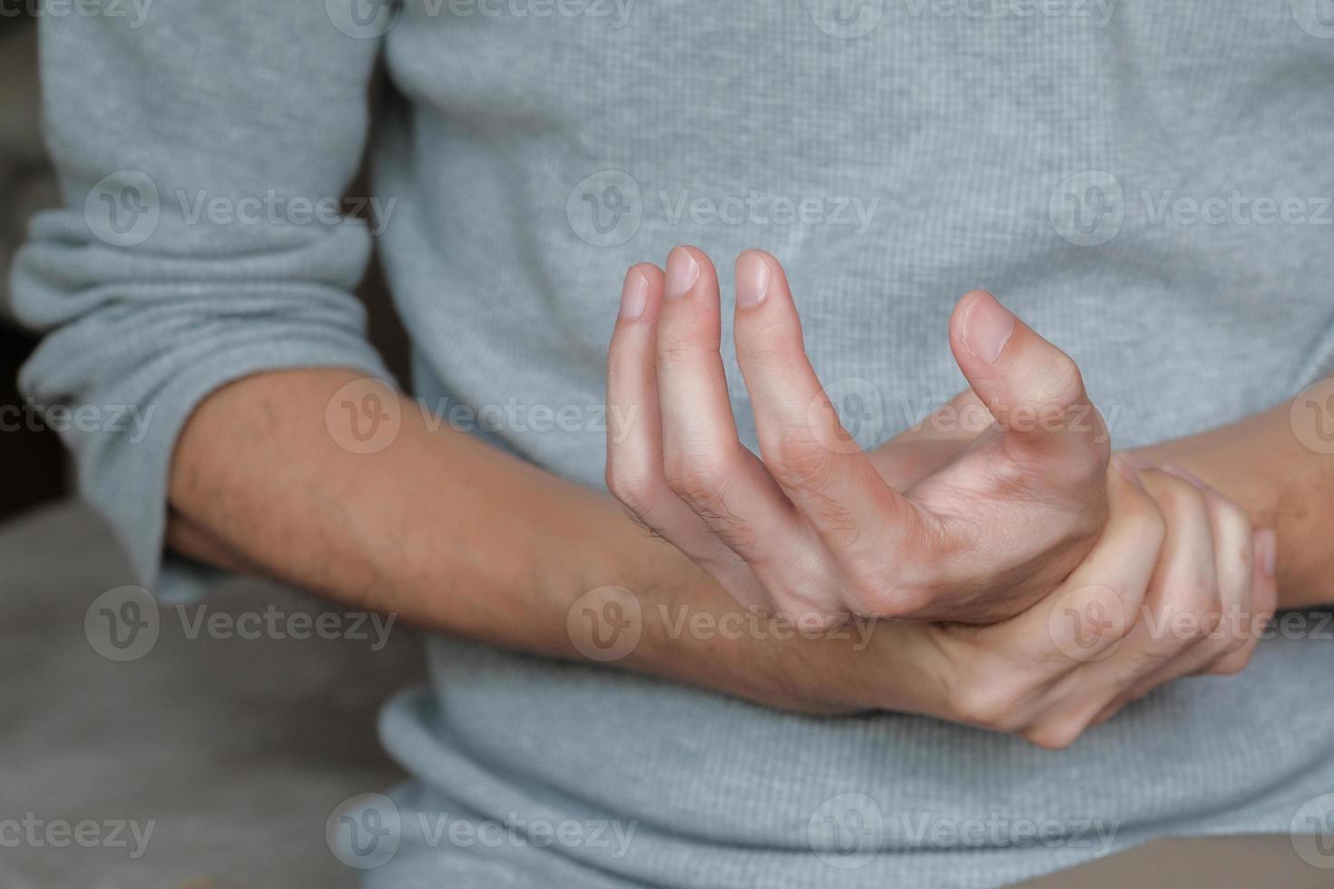 homem asiático segurando a mão com sintomas de fraqueza muscular, dormência e paralisia após a vacinação. Síndrome de Guillain Barre causa rara pelo conceito de desordem autoimune. foco seletivo. foto