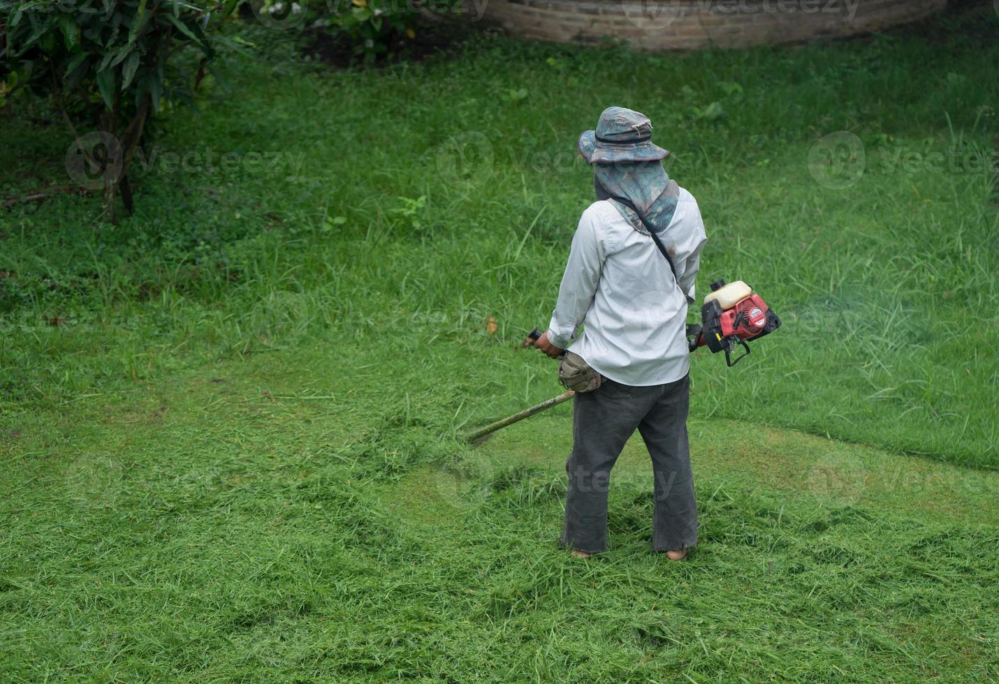 homem cortando grama foto