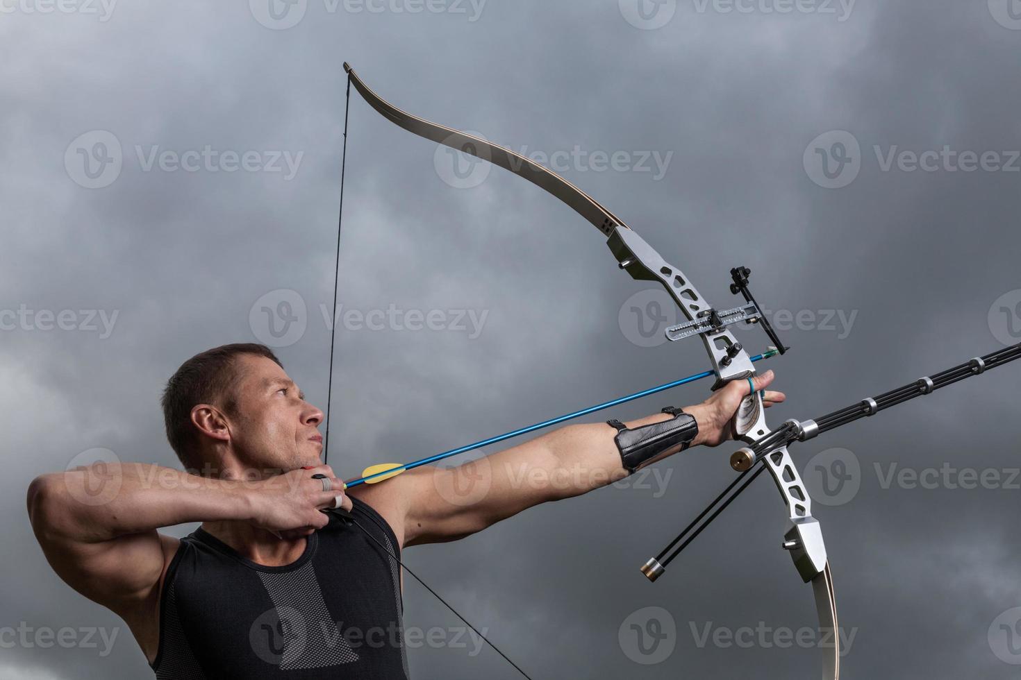 um arqueiro masculino dando um tiro com seu arco e flechas foto