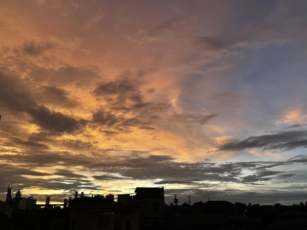 céu crepuscular muito bonito, uma mistura de cores laranja e azul. bela vista do céu à noite. nuvens, céu e arco-íris que enfeitam a atmosfera à tarde. vista noturna em jacarta. borrão foto