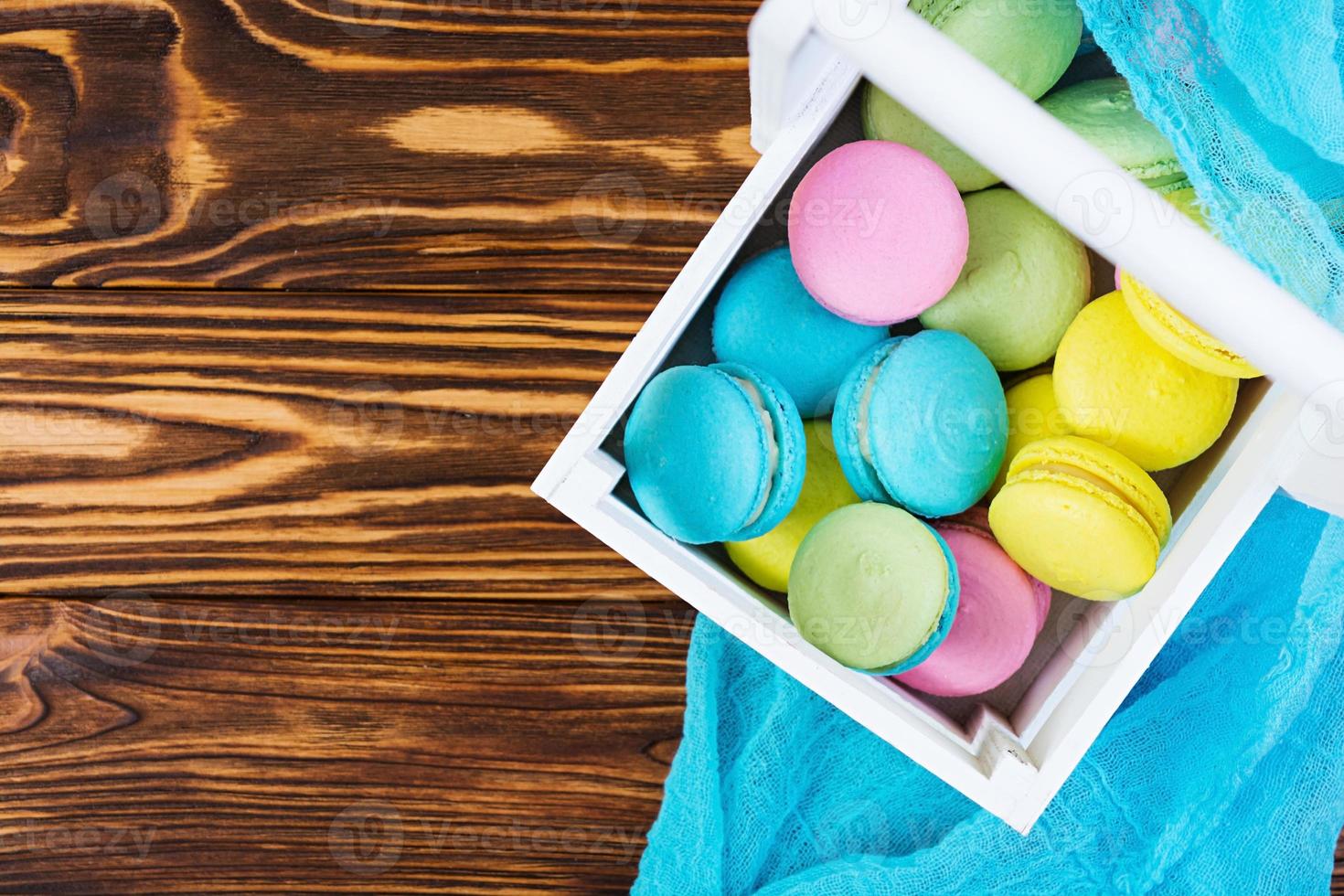 deliciosos bolos de macaron coloridos em fundo de madeira foto