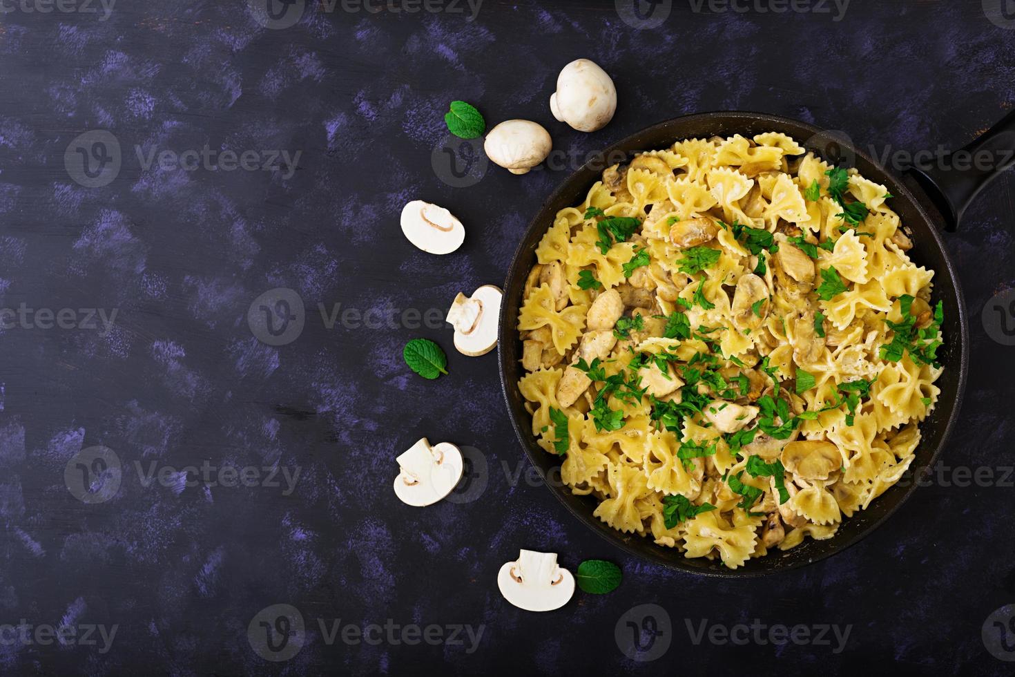 farfalle com frango e cogumelos em molho cremoso. vista do topo foto