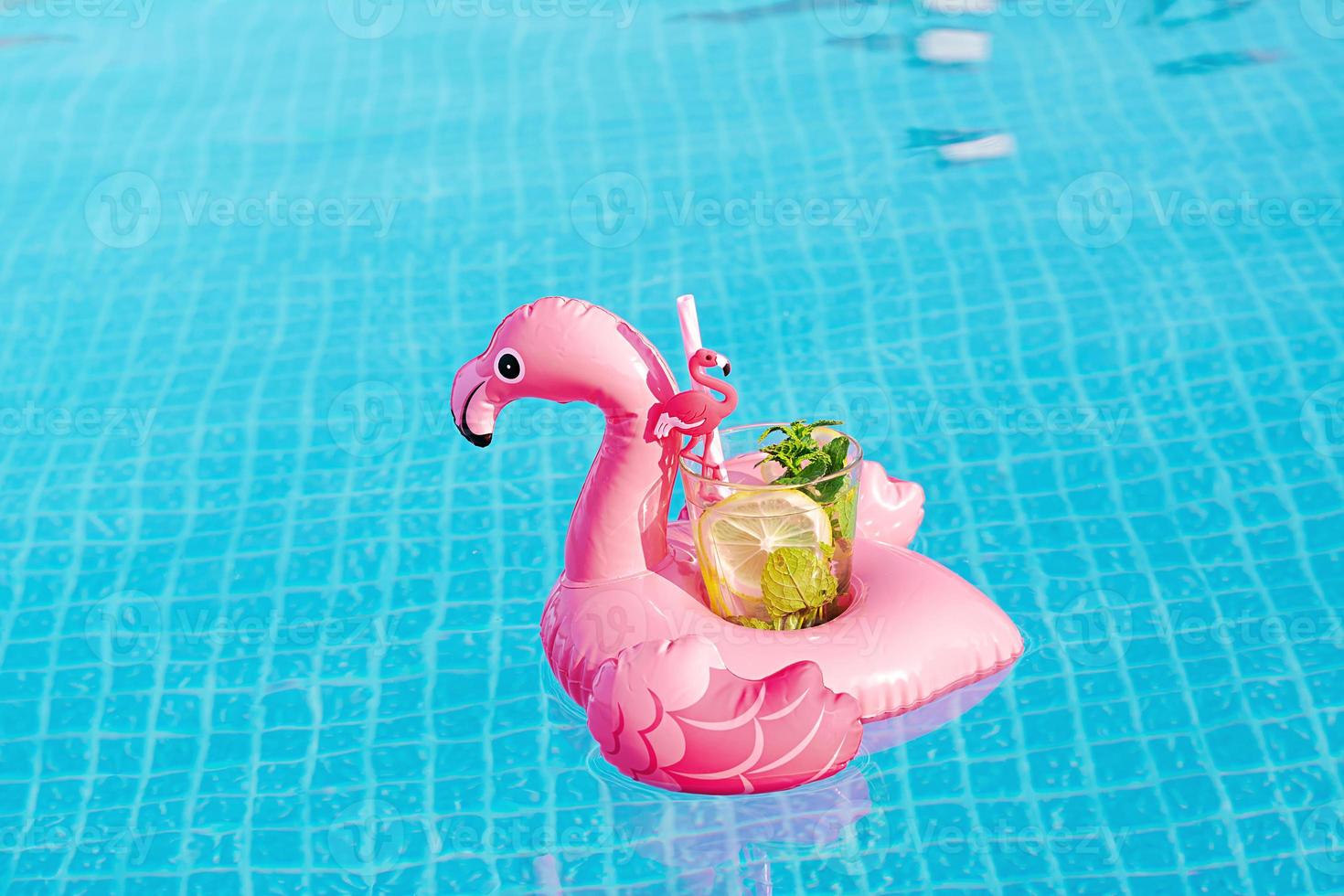 fresco coctail mojito no brinquedo inflável rosa flamingo na piscina. conceito de férias. foto