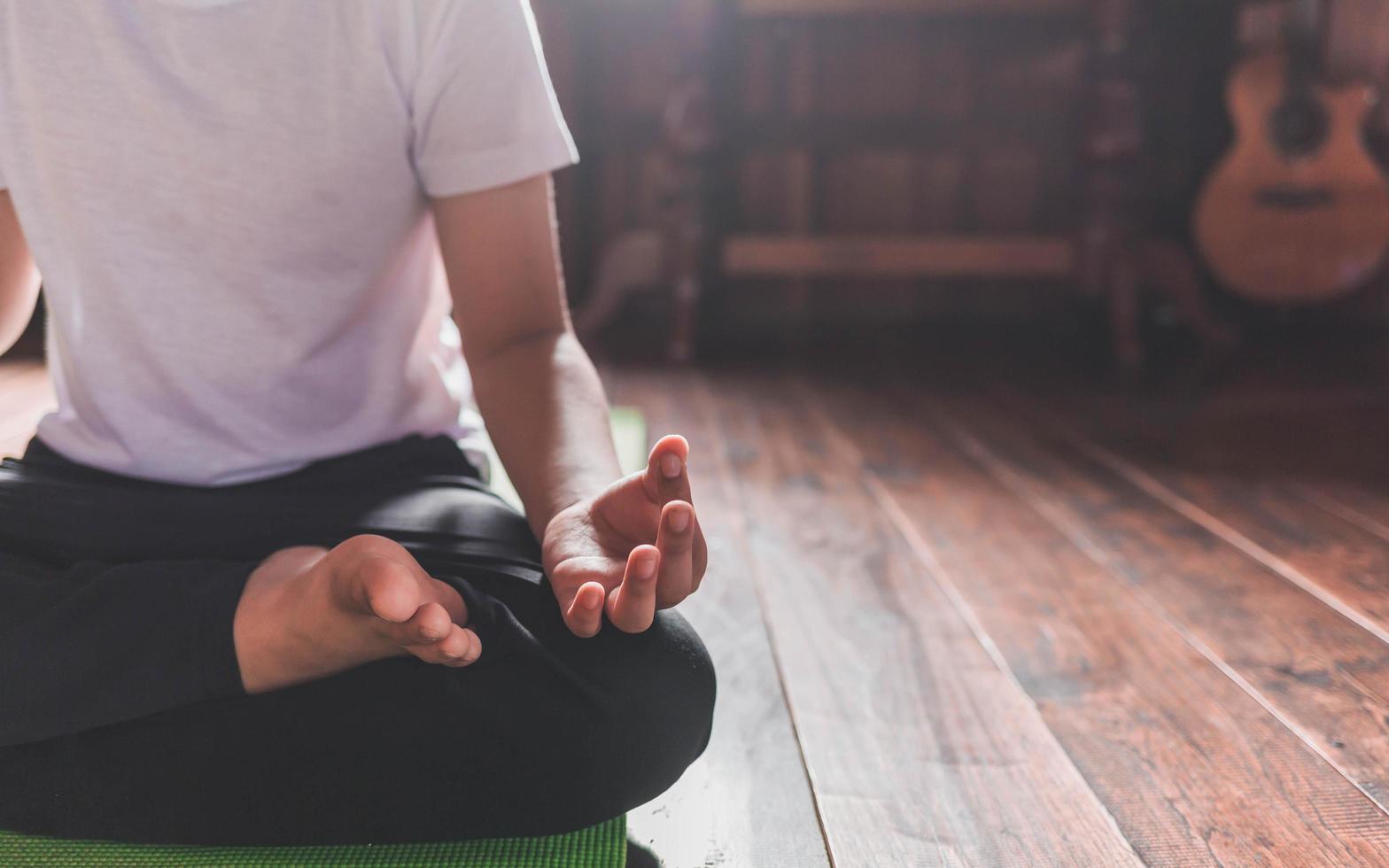 menino asiático meditando sozinho em casa pacificamentev foto