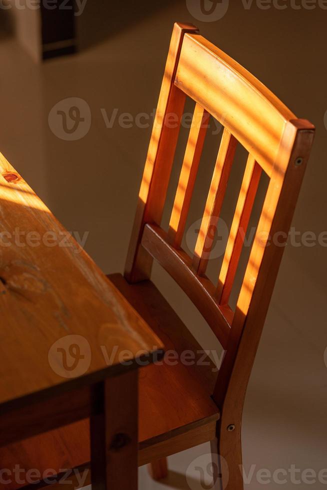cadeira e mesa de madeira em uma casa iluminada pelo sol foto