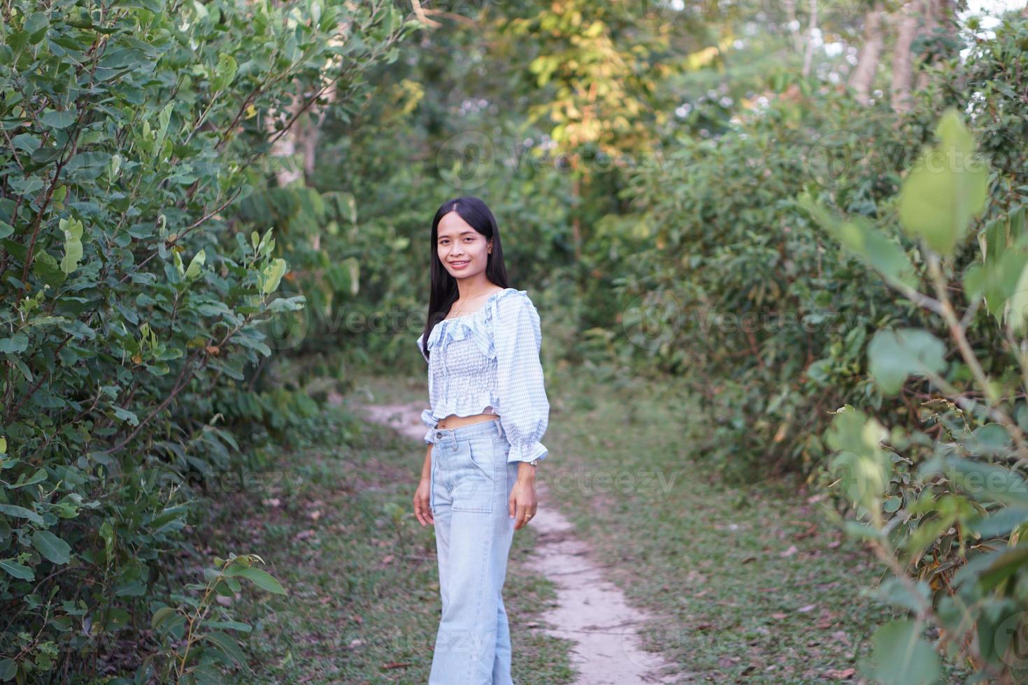 mulher asiática em um vestido azul claro está andando alegremente na estrada foto