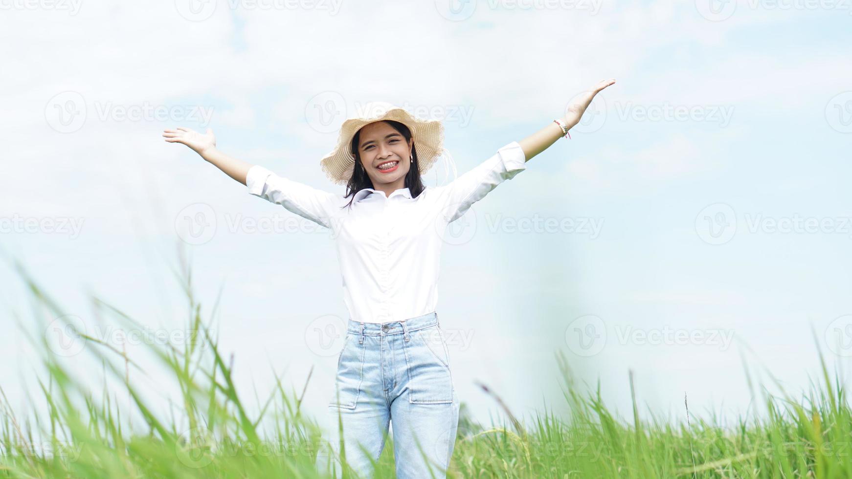 mulher asiática no fundo do campo de arroz verde foto